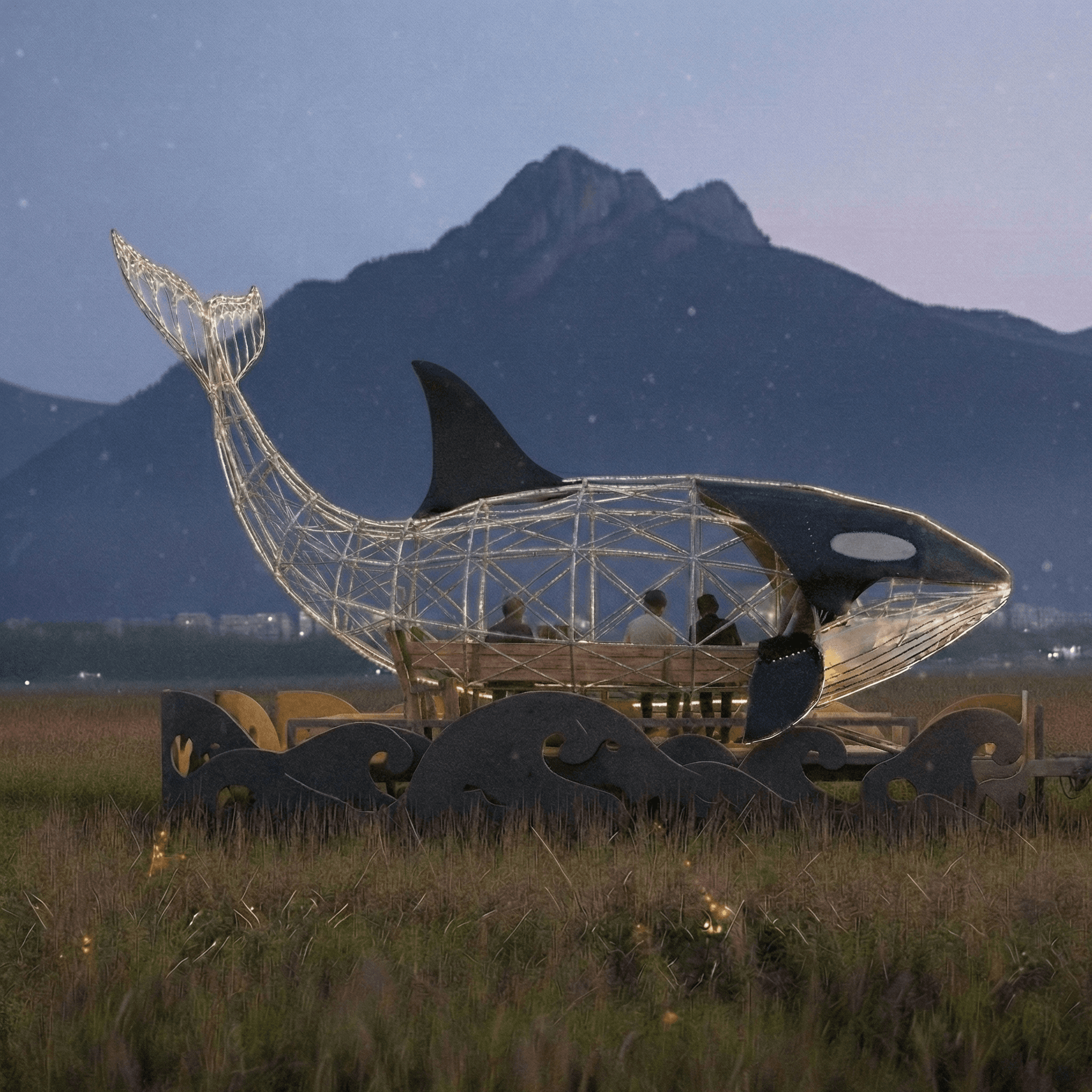 Concept render of Orcar — a large illuminated orca sculpture with steel wireframe, glowing at dusk with mountains in the background